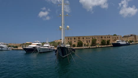 sunny harbour in valletta - malta with yachts docked along mediterranean buildings