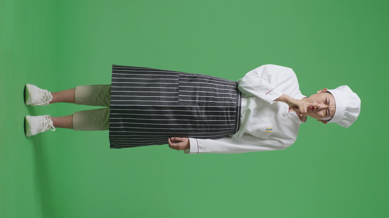 Full Body Of Asian Woman Chef Looking At Camera And Making Shh Gesture In The Green Screen Background Studio