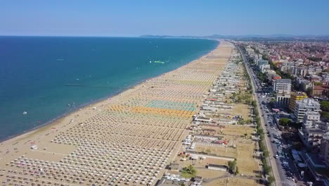 rimini resort beach in italy with a lot of parasols and sunbeds during summertime - aerial drone shot