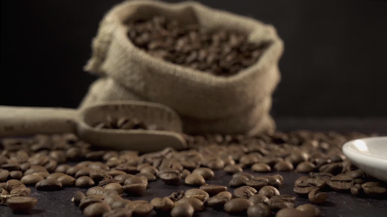 Tazza da caffè bianca e chicchi tostati su tavolo scuro