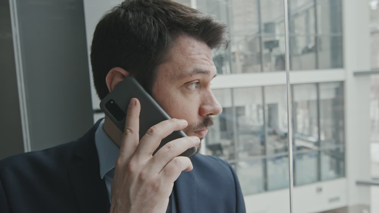 Close-Up of Male Advocate Talking on Phone in Glass Lift