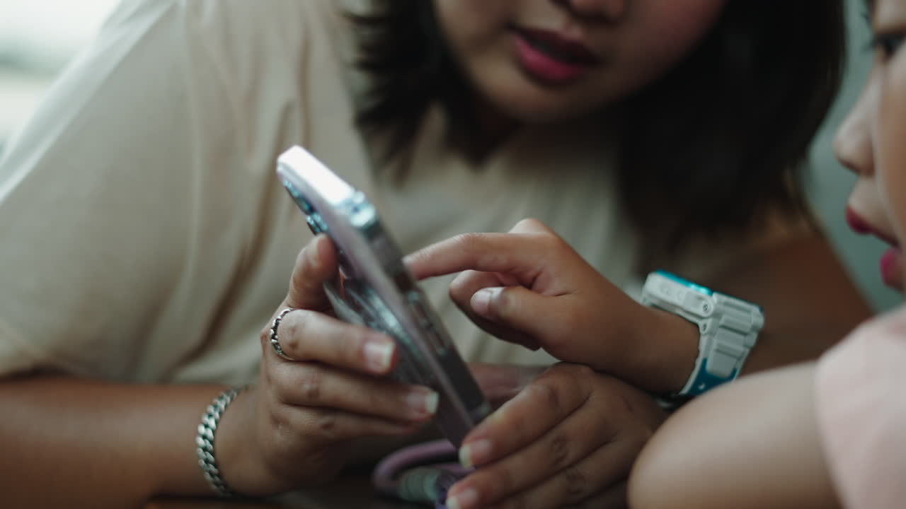 Close-up of Child's Hand Tapping on Smartphone Screen