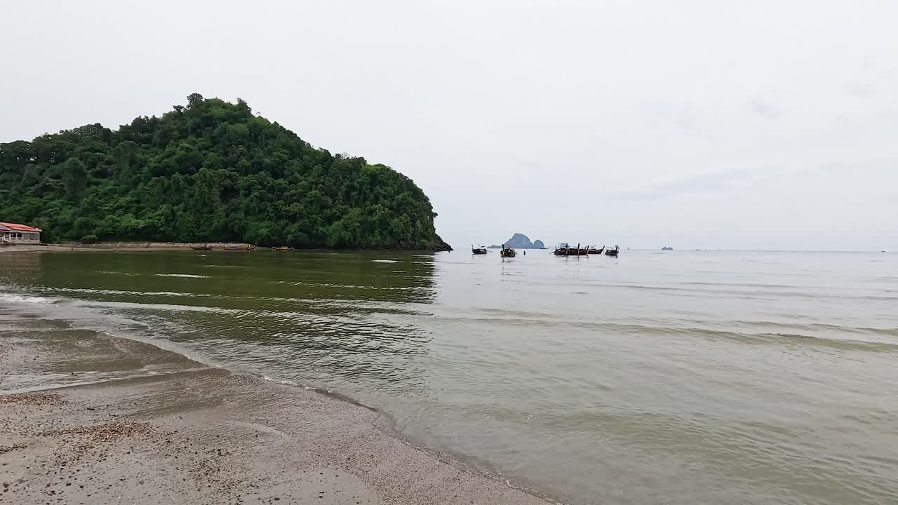 olas tranquilas y barcos cerca de la isla exuberante