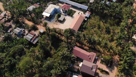 Descripción-Aérea-De-Los-Edificios-Escolares-Y-La-Comunidad-Durante-Un-Día-Soleado-Y-Ventoso-En-Battambang,-Camboya