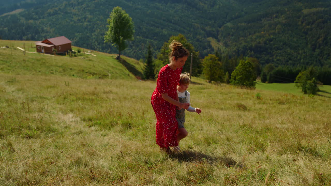 Madre che sale una collina con la figlia. Donna e bambina che camminano su un pendio di montagna.