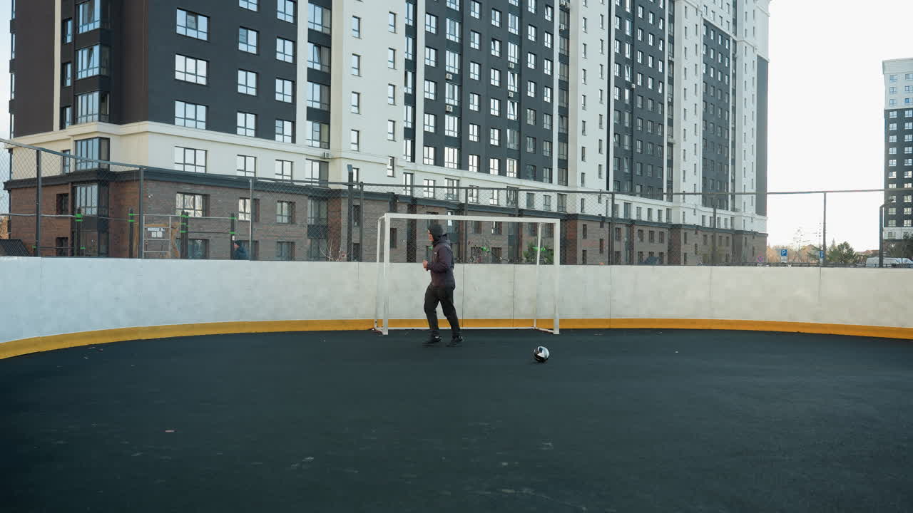 deportista corriendo en una amplia arena deportiva al aire libre, capturado a mitad de paso, haciendo hincapié en el atletismo y el entorno urbano con edificios de gran altura en el fondo