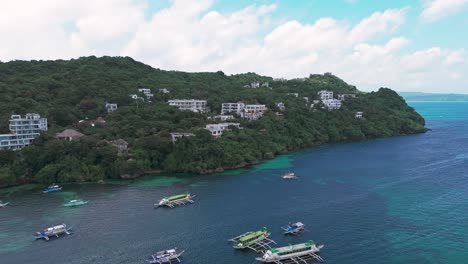 aerial view of boracay’s hillside resorts, lush greenery, and boats on turquoise waters. perfect for travel, tourism, real estate, and tropical paradise visuals
