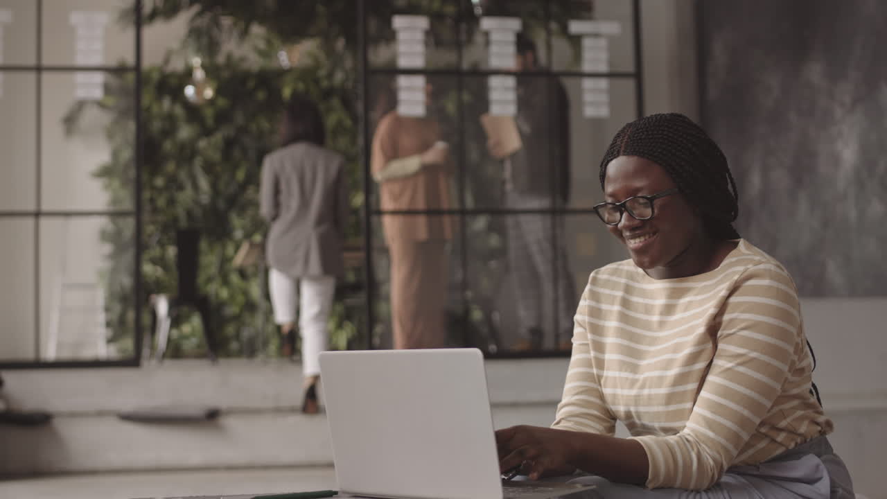 African Woman Using Computer and Smiling