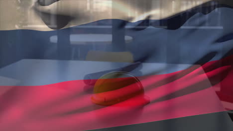 animation of flag of russia over hard hat and architect's blueprints on table