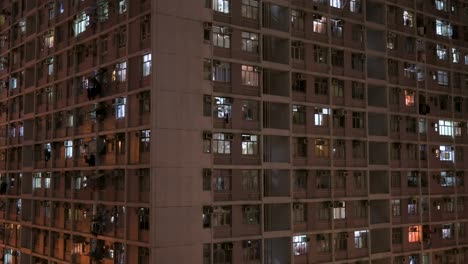 Una-Vista-Nocturna-De-Un-Edificio-De-Viviendas-Públicas-De-Gran-Altura-Lleno-De-Gente-En-Hong-Kong