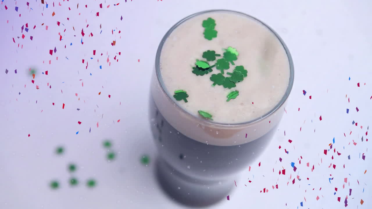 Shamrock-topped drink with confetti falling animation on white background