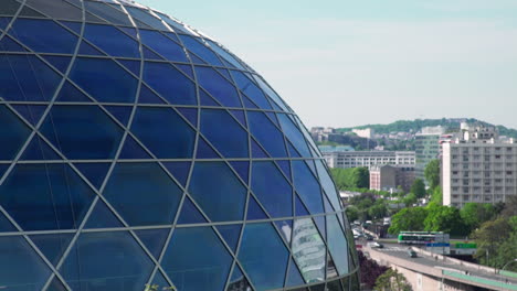 a closer look at the modern glass dome structure of the seine musicale concert hall in paris, france, with traffic in the background