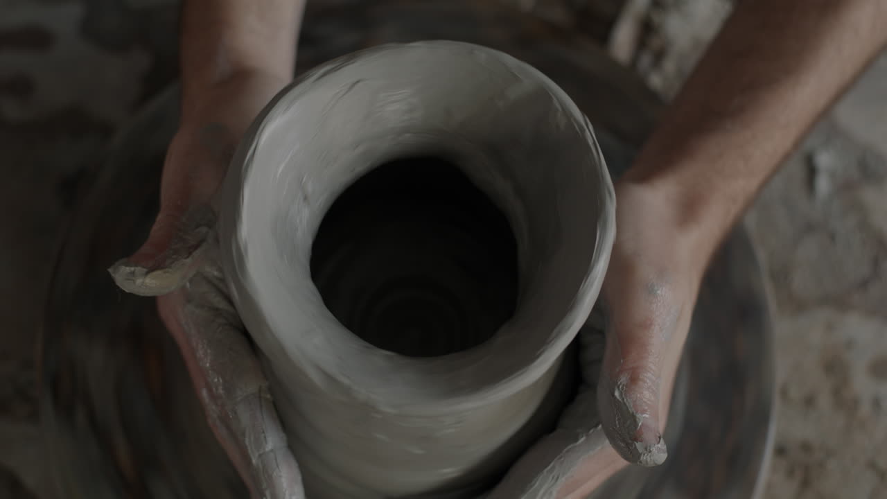 manos moldeando arcilla en una rueda de cerámica