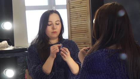 woman applying lipstick in a dressing room