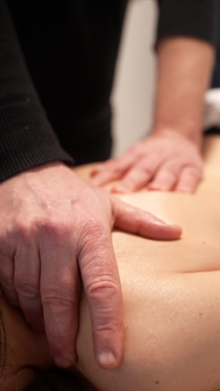 Professionel terapeut giver en afslappende rygmassage til en kvinde