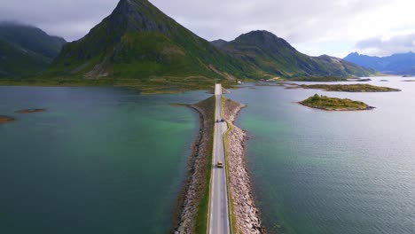 沿著一輛車沿著洛福<unk> (lofoten) 北挪威的弗雷德旺橋 (fredvang bridge) 駕駛,在夏天的雲天下,海洋水在淡藍色和綠色色調中閃<unk>.