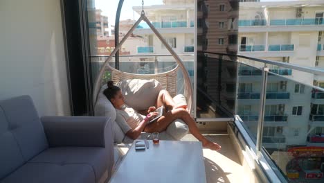 woman working on laptop on balcony