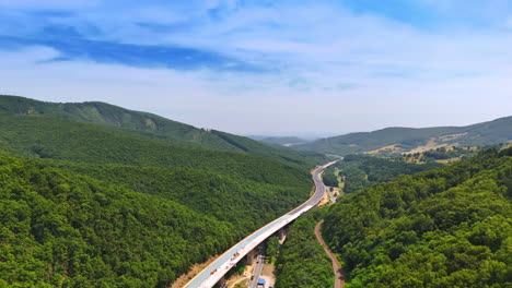 hilly scenic winding road. a highway stretches through lush green hills, showcasing a tranquil landscape and clear blue skies in the distance