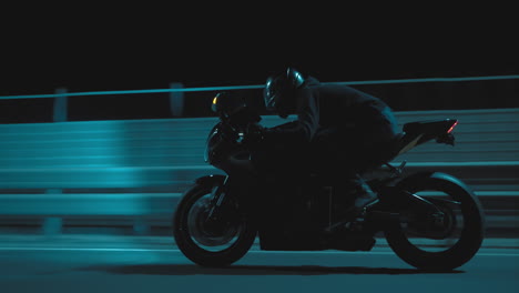 a man rides a sports motorcycle on a night track