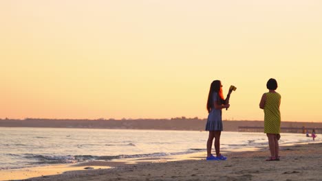 pretty girl in sunglasses taking photo of herself on the sea background. evening landscape on the sea shore and women standing at sunset.