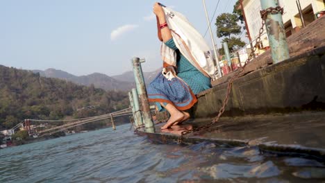 Joven-India-Aislada-Sentada-En-La-Orilla-Del-Río-Ganges-Desde-Un-ángulo-Diferente-Se-Toma-Un-Video-En-La-Orilla-Del-Río-Ganga-Rishikesh-Uttrakhand-India