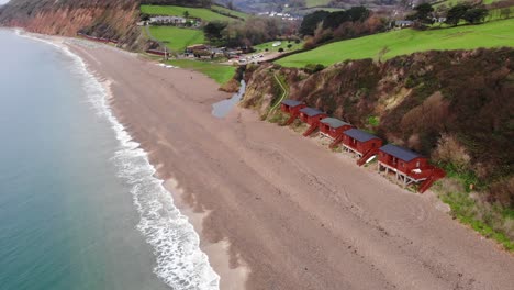 Erstaunlicher-4K-Luftzoom-In-Richtung-Der-Küstenlinie-über-Den-Rollenden-Wellen-Des-Britischen-Strandes-Von-Branscombe