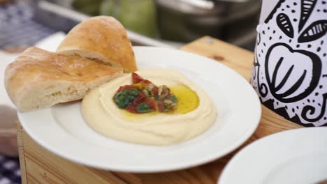 cámara lenta - plato de hummus en plato blanco en el festival de comida - cerrar