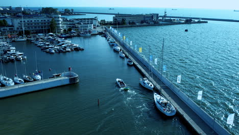 crucero de barcos por un puerto deportivo en gdynia con un puente y edificios en el fondo