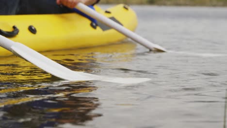 caucasian couple having a good time on a trip to the mountains, kayaking together on a lake