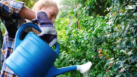 female gardener watering plants with watering can