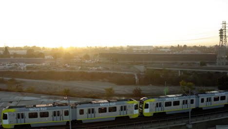 metro rail train on elevated track at sunset in los angeles