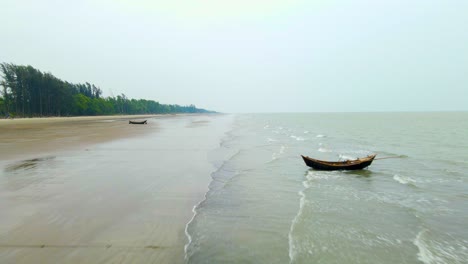 empty kuakata sea beach with wooden fishing boats aerial by drone in bangladesh indian ocean