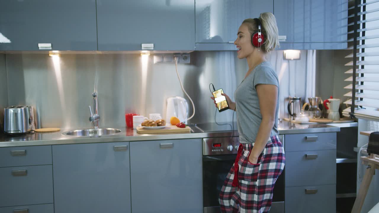 mujer escuchando musica en la cocina