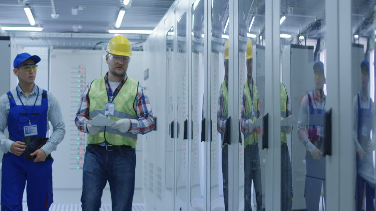 Electrical Engineers Inspecting Control Panel
