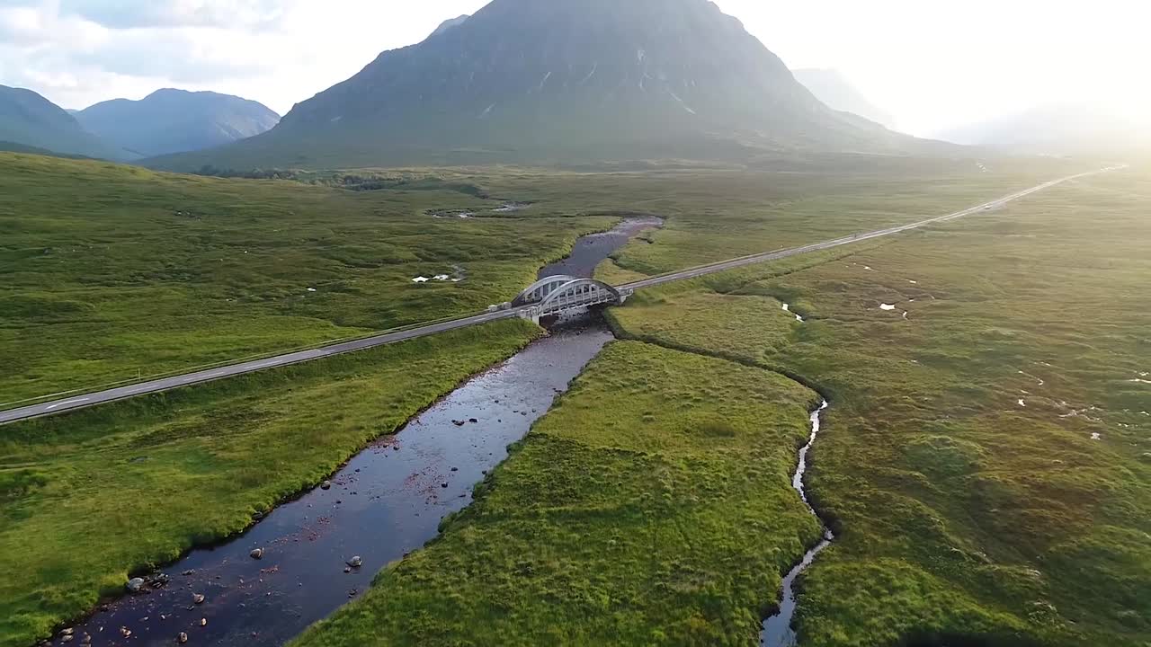 The only road in the glencoe valley filmed from the drone. A long river passes underneath the bridge.This scenic place has been used as a location in several films