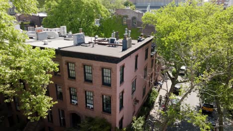Ascending-aerial-view-in-front-of-a-brownstone-house-revealing-the-skyline-of-Brooklyn,-NY,-USA