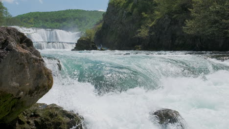 Una-Cascada-Con-Una-Gran-Cantidad-De-Agua-En-Un-Río-De-Montaña-Limpio-Y-Salvaje