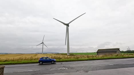 wind turbines spinning, car passing by