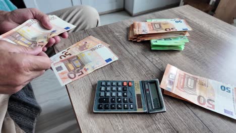 man sitting at home counts money in euros