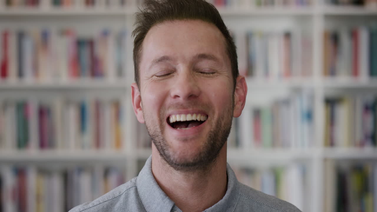 retrato feliz hombre caucásico maestro riendo disfrutando de una exitosa educación estilo de vida de carrera en el fondo de la biblioteca estantería