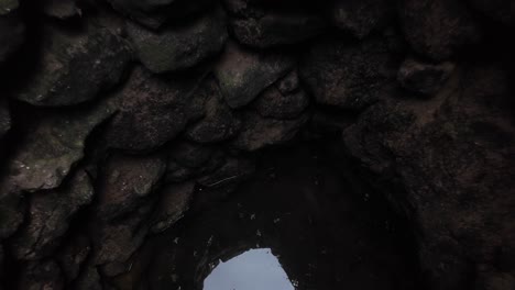 una exploración revela el interior de un pozo histórico en crimea, mostrando paredes de piedra y un vislumbre de luz en el fondo.