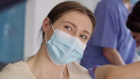 Tracking-video-of-happy-woman-taking-selfie-during-vaccination