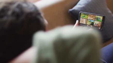 Mixed-race-mother-and-daughter-using-tablet-in-blanket-tent