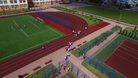 Adolescentes-Jugando-En-El-Campo-De-Fútbol-En-El-Patio-De-La-Escuela.-Vista-Aérea-Del-Campo-Deportivo