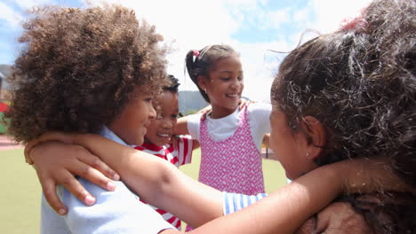 children in school hugging and smiling together, enjoying outdoor activity