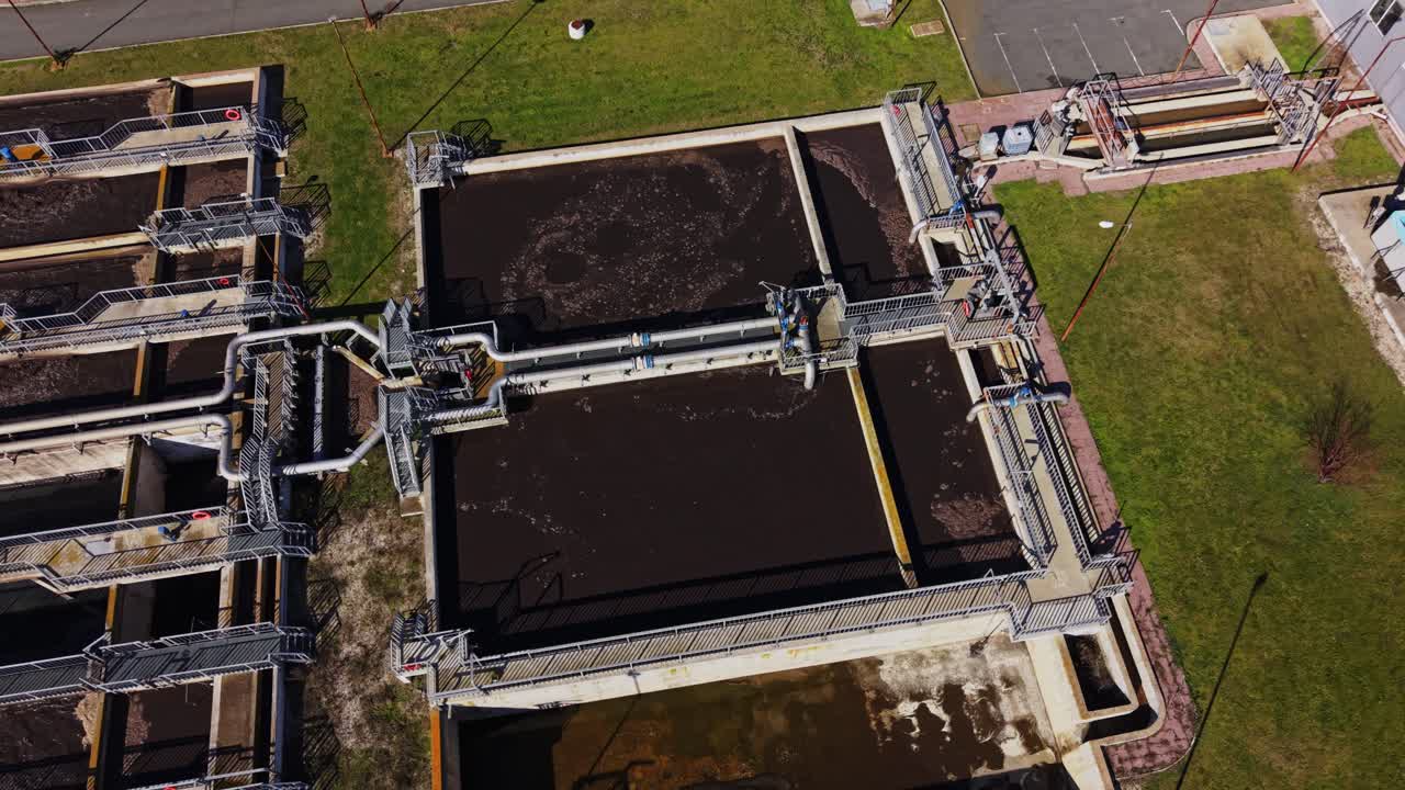 Water treatment plant uses large tanks and pipes in bright light