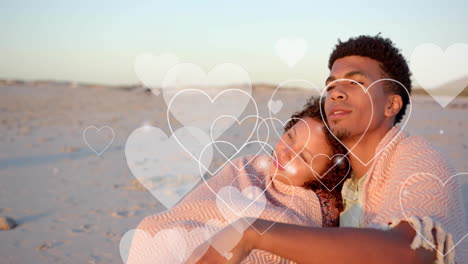 animation of hearts moving over diverse couple in love embracing on beach in summer