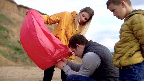 family preparing to launch a sky lantern on the beach