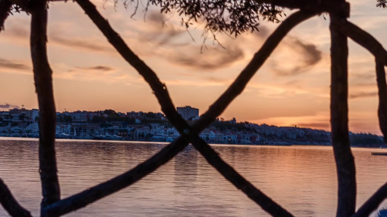 Solen går ned over byen Port Mahon og bygninger set fra vandet på Menorca, Spanien, statisk udsigt i den gyldne time til skumringens sidste lys