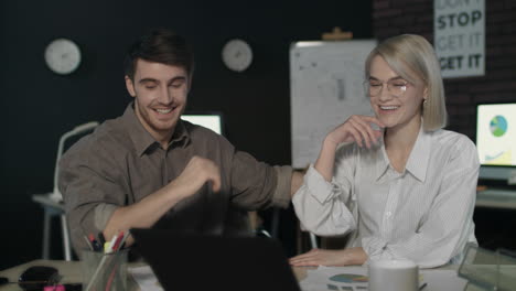 Business-couple-giving-five-in-dark-office.-Excited-team-celebrating-success.